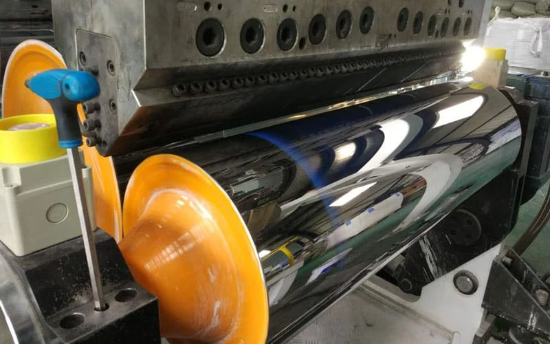 Melt leaving a sheet die onto the polished roller of a calender