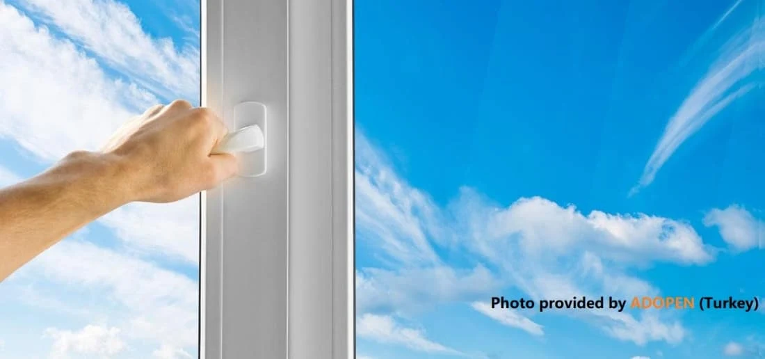 Mano abriendo una ventana de PVC blanca