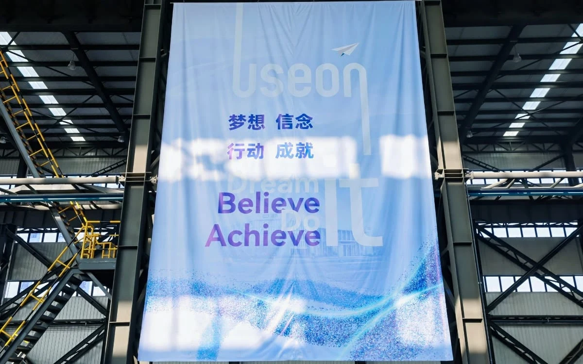 "Believe, Achieve" banner in the new factory workshop