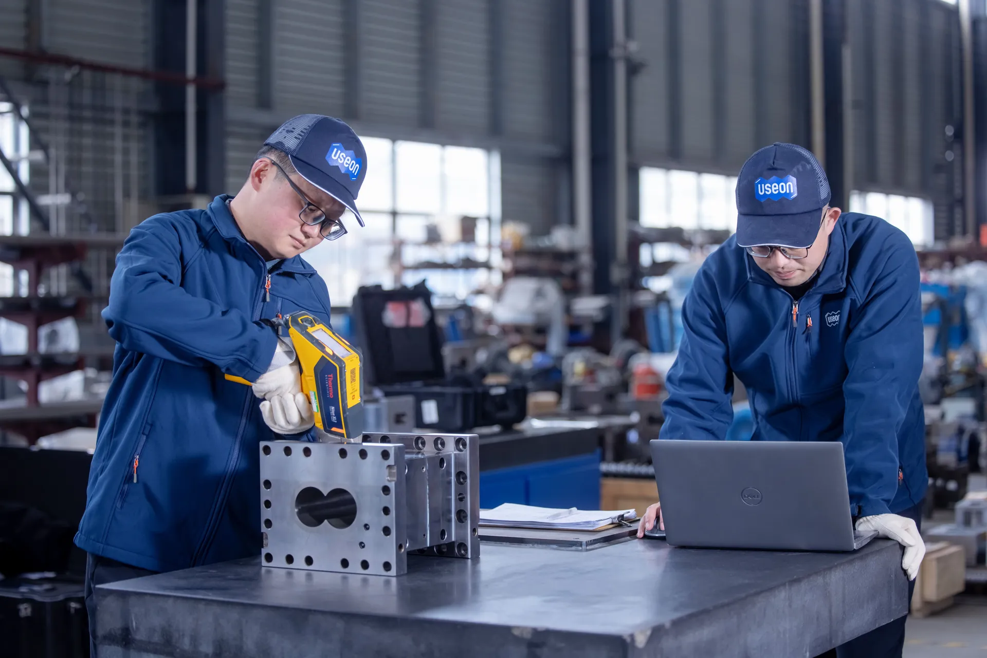 Inspectors checking a barrel section with a handheld metal analyser